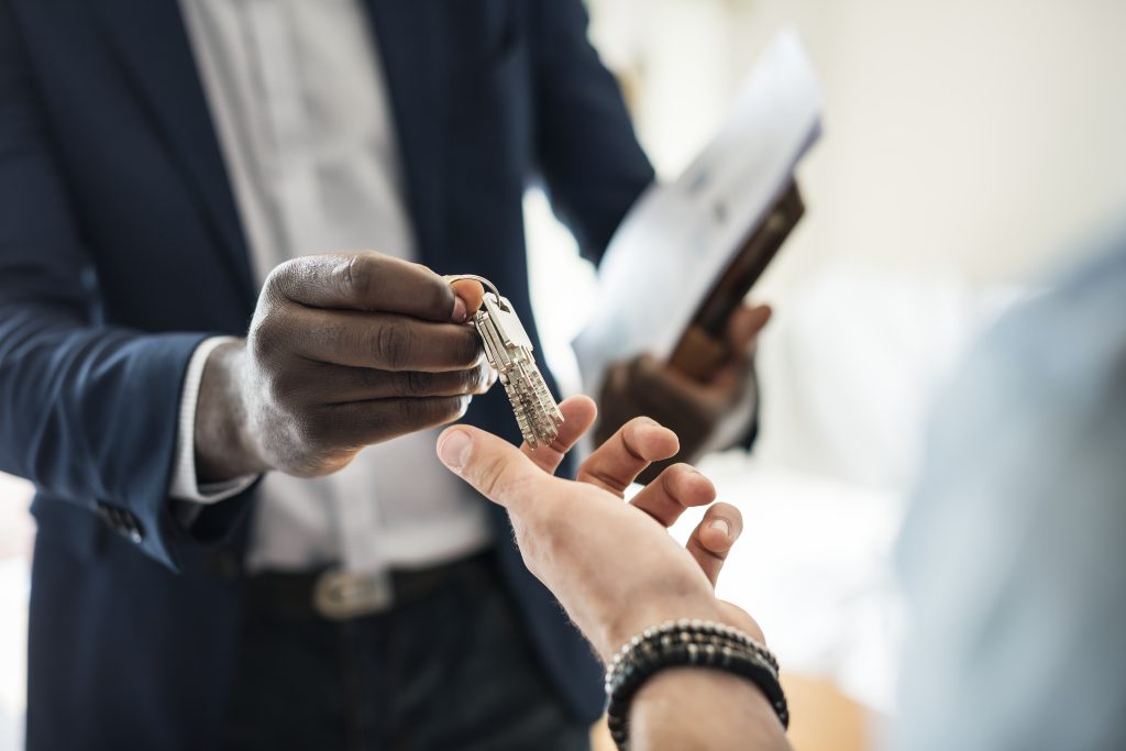 real estate agent handing the house key to a client